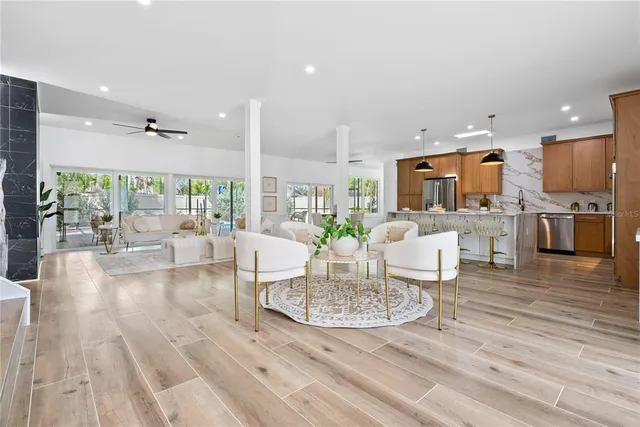 a living room with furniture wooden floor and a kitchen view
