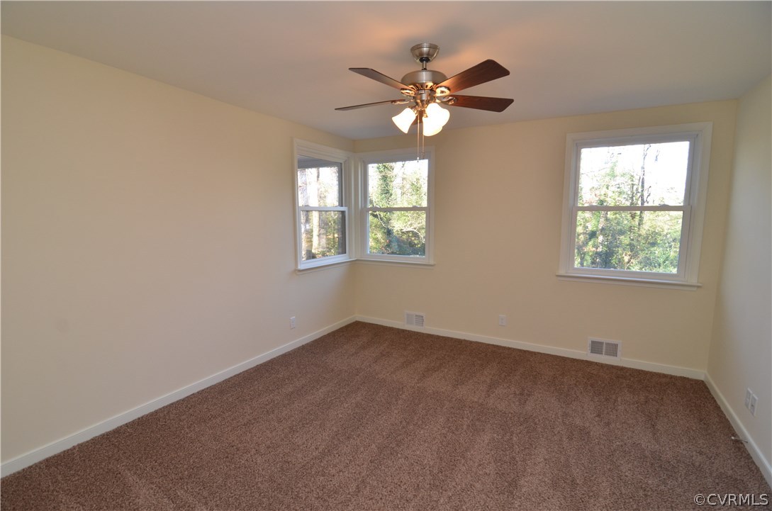 3308 Osborne Road Chester, VA 23831 - Photo 9 of 26 an empty room with windows and chandelier fan