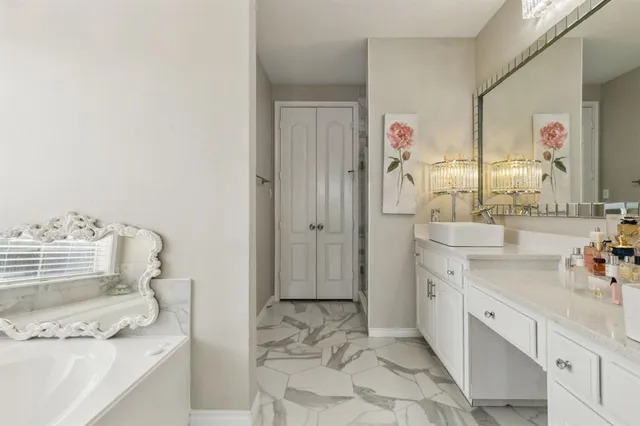 a spacious bedroom with a bed and a chandelier