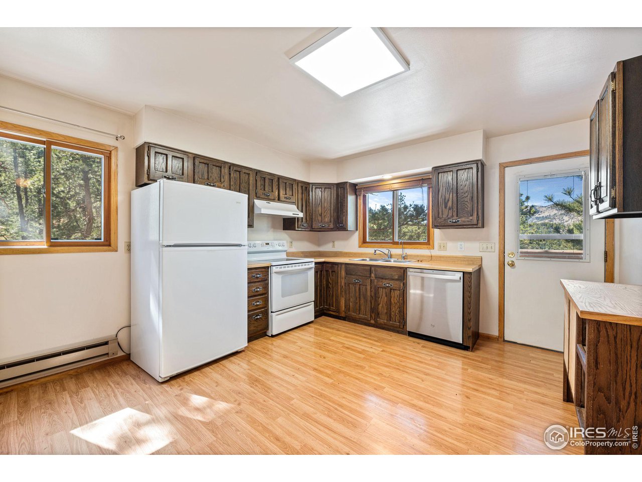 757 Peakview Road Boulder, CO 80302 - Photo 11 of 34 a kitchen with a refrigerator a sink dishwasher with a dining table and wooden floor