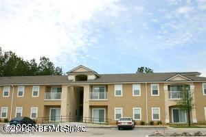 a front view of a residential apartment building with a yard