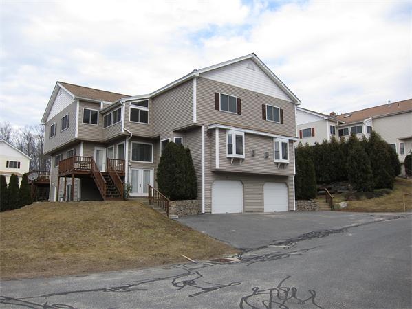 a view of a white house with large windows next to a road
