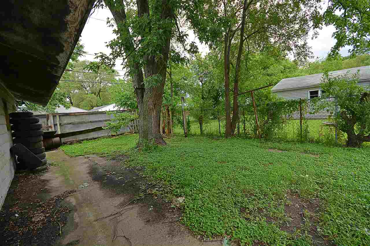 916 Windsor Road Loves Park, IL 61111 - Photo 13 of 14 a view of backyard with table and chairs and a large tree
