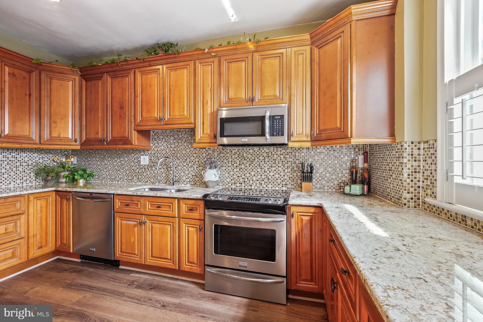 323 W Street Northeast Washington, DC 20002 - Photo 8 of 22 a kitchen with granite countertop a sink a stove and cabinets