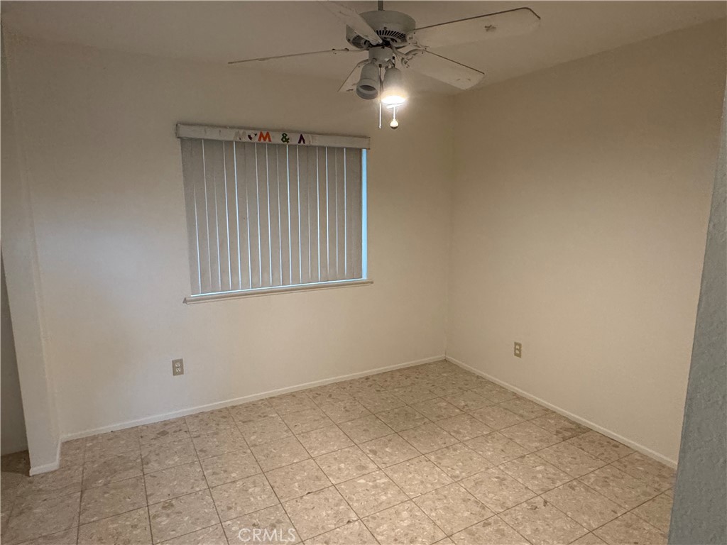 1731 Starboard Way Perris, CA 92571 - Photo 4 of 19 an empty room with a ceiling fan and window