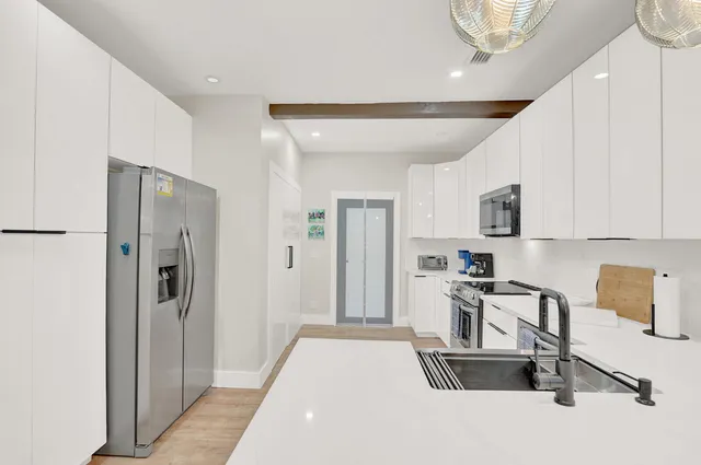 a kitchen with stainless steel appliances granite countertop a refrigerator and a stove top oven