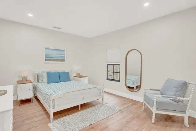 a bedroom with a bed and a potted plant on dresser