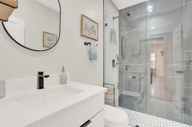 a bathroom with a sink a toilet and a mirror