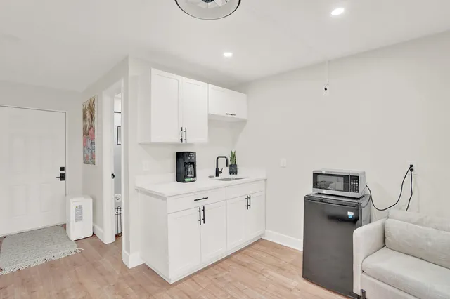 a kitchen with white cabinets and stainless steel appliances
