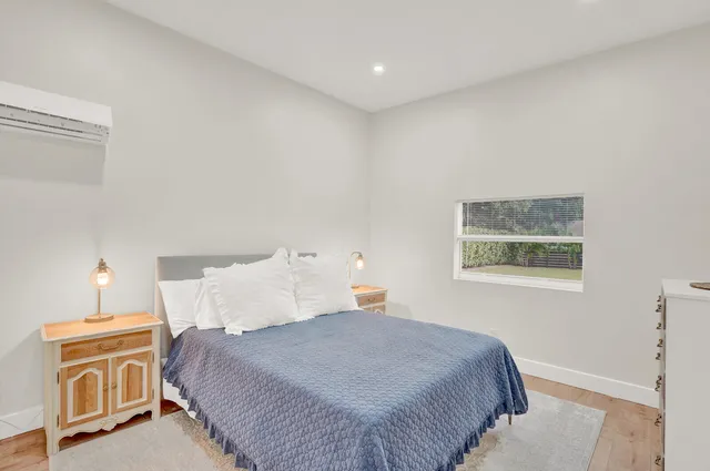 a bedroom with a bed and a lamp on the dresser