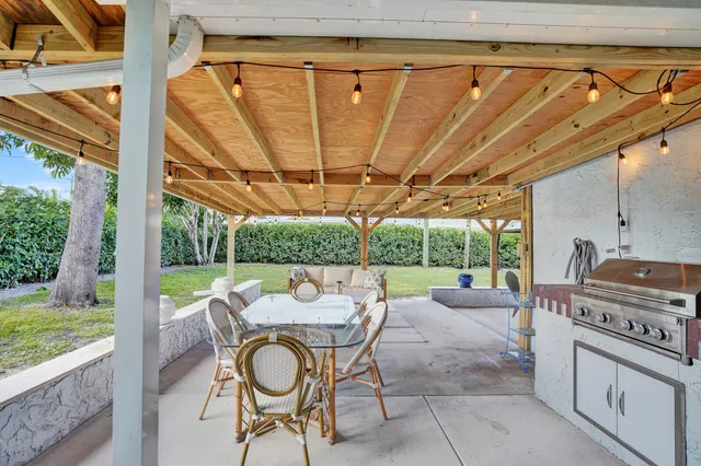 a view of a patio with a table chairs and a backyard