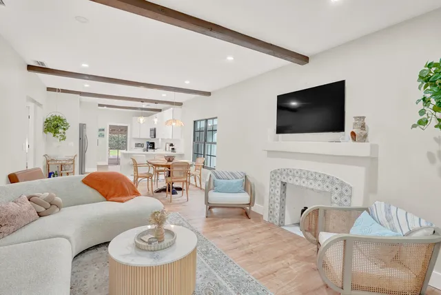 a living room with furniture a fireplace and a flat screen tv
