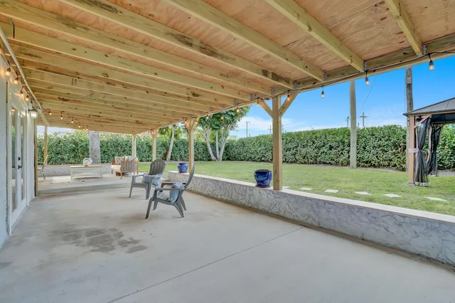 a view of a house with backyard and sitting area