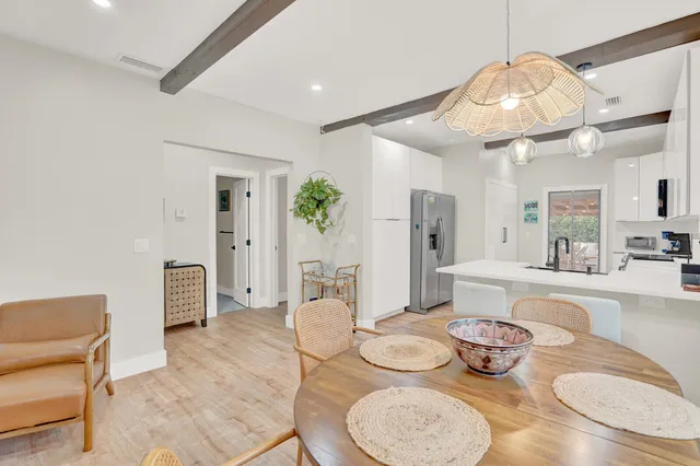 a dining room with furniture a kitchen and chandelier