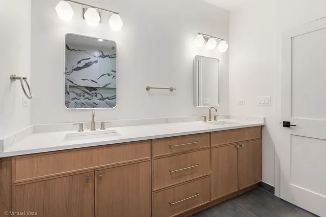 a bathroom with a double vanity sink and a mirror