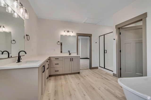 3317 South 1000 West, Unit 6010 Logan, UT 84321 - Photo 9 of 34 Bathroom with double vanity, a shower stall, light wood-style flooring, and a soaking tub