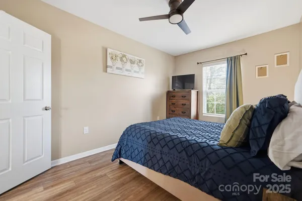 a bedroom with a bed and wooden floor