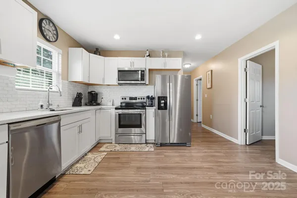 a kitchen with stainless steel appliances granite countertop a refrigerator sink and stove