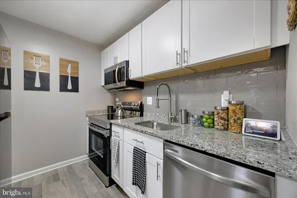 a kitchen with stainless steel appliances granite countertop a sink stove and cabinets