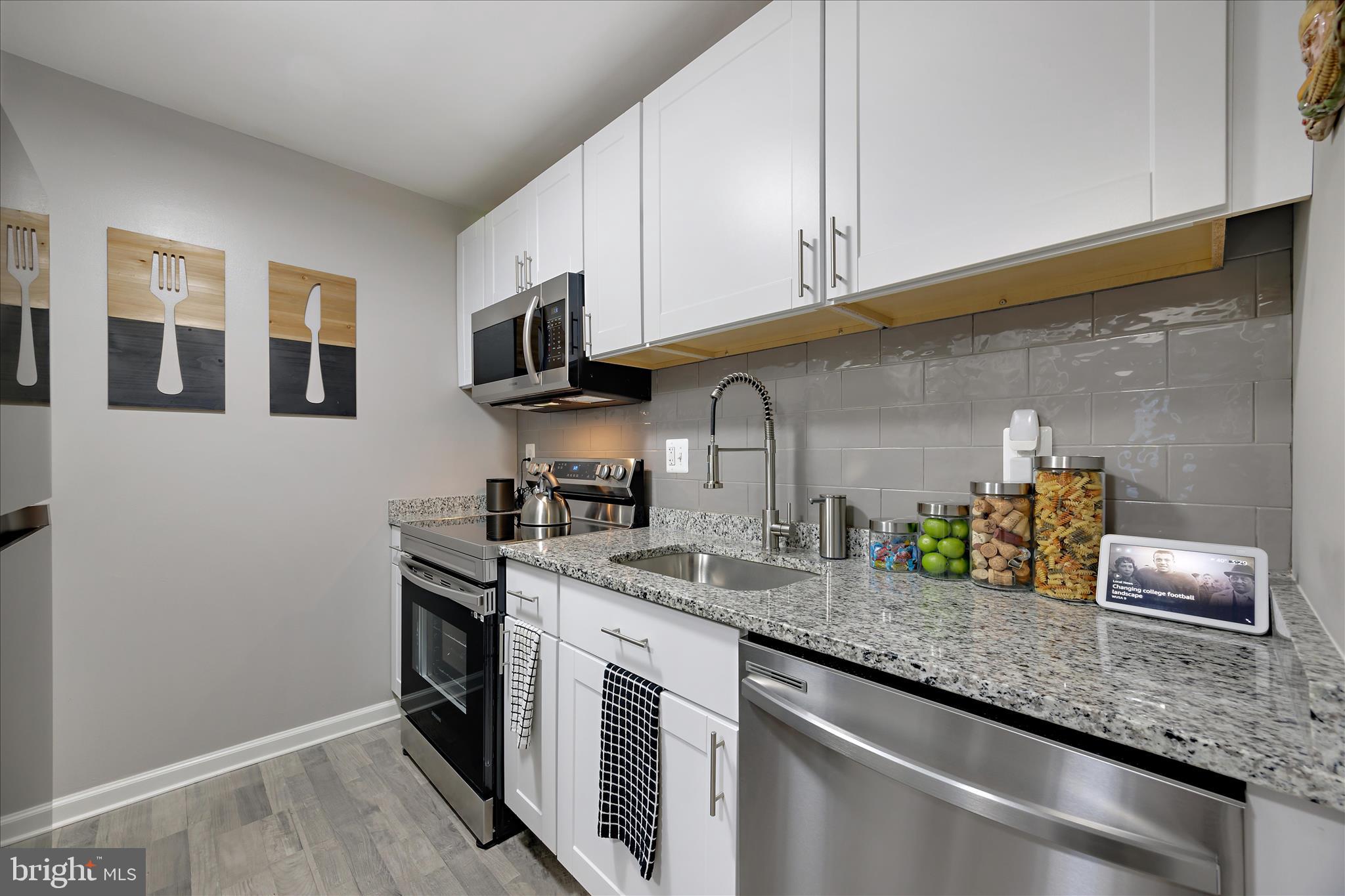 7314 Split Rail Lane Laurel, MD 20707 - Photo 16 of 32 a kitchen with stainless steel appliances granite countertop a sink stove and cabinets