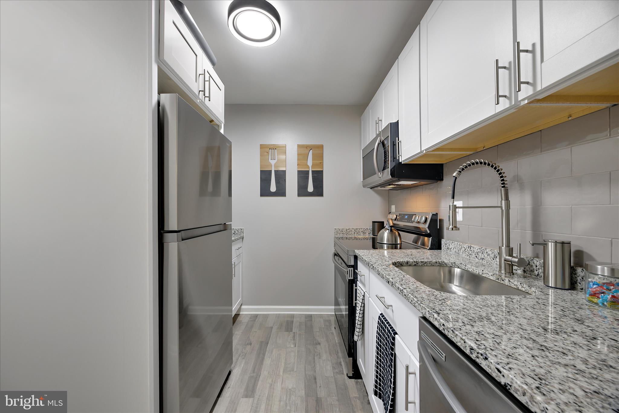 7314 Split Rail Lane Laurel, MD 20707 - Photo 17 of 32 a kitchen with a sink a refrigerator and cabinets