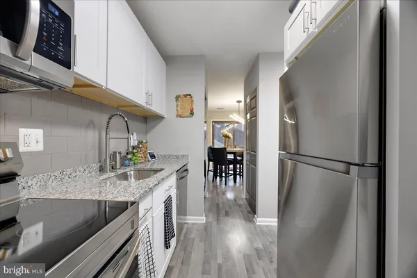 a kitchen with kitchen island a counter top space a sink and stainless steel appliances