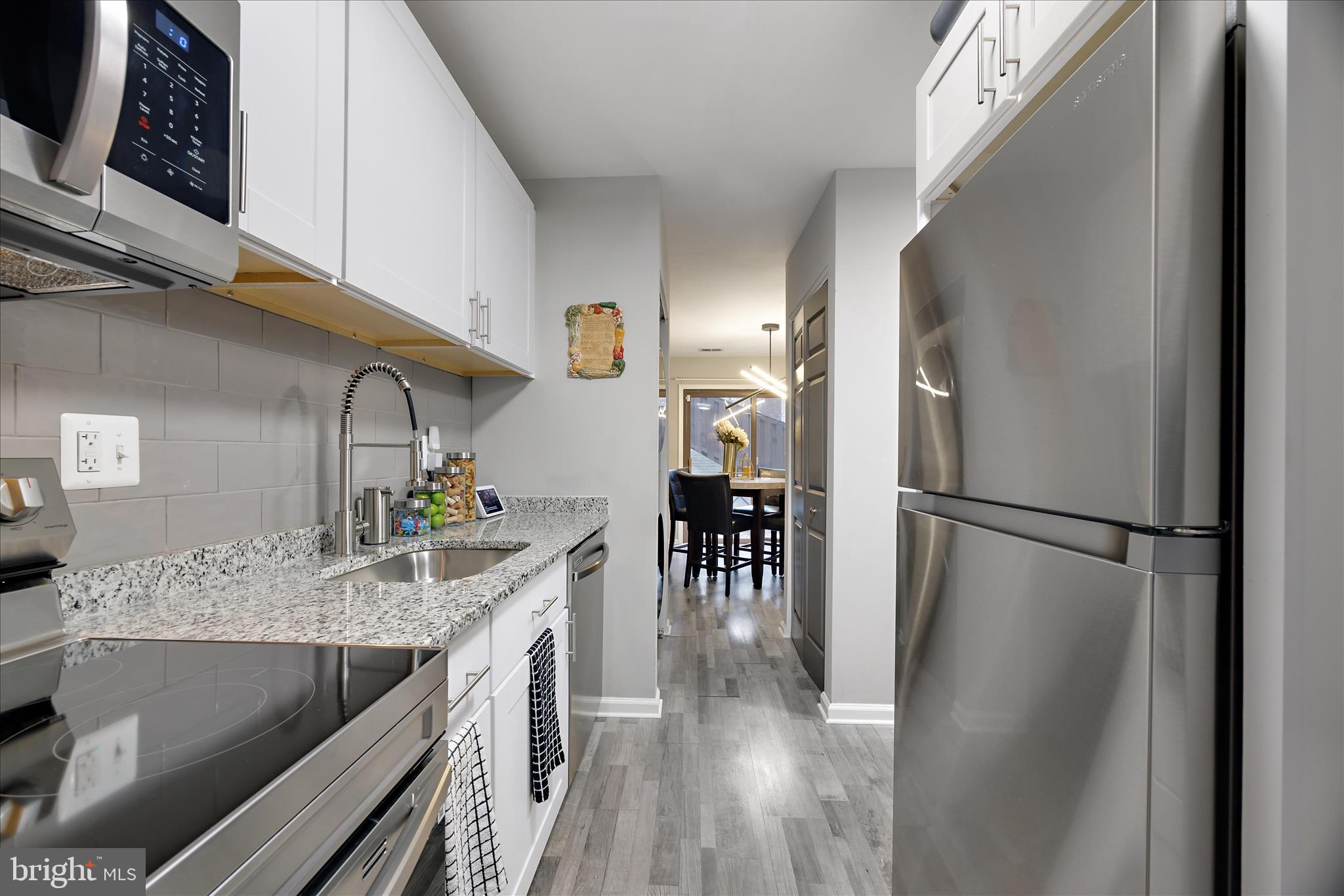 7314 Split Rail Lane Laurel, MD 20707 - Photo 20 of 32 a kitchen with kitchen island a counter top space a sink and stainless steel appliances