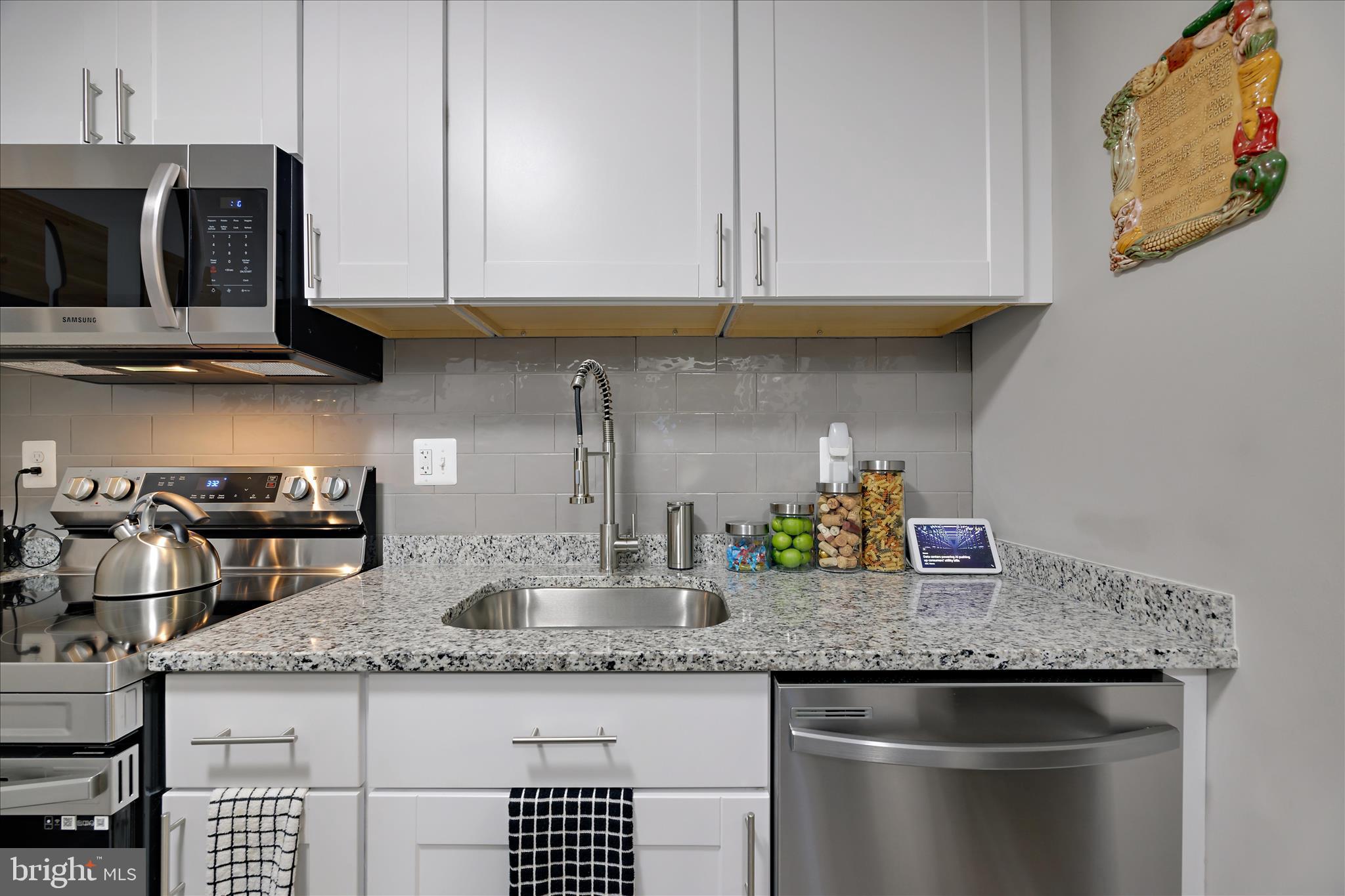 7314 Split Rail Lane Laurel, MD 20707 - Photo 21 of 32 a kitchen with granite countertop a sink a stove and cabinets