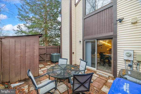 a backyard of a house with dining table and chairs with wooden floor