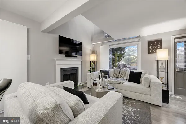 a living room with furniture a flat screen tv and a fireplace