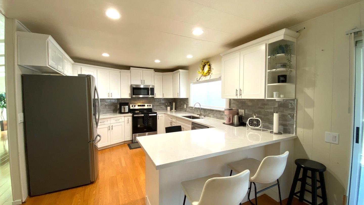 a kitchen with refrigerator a sink and chairs