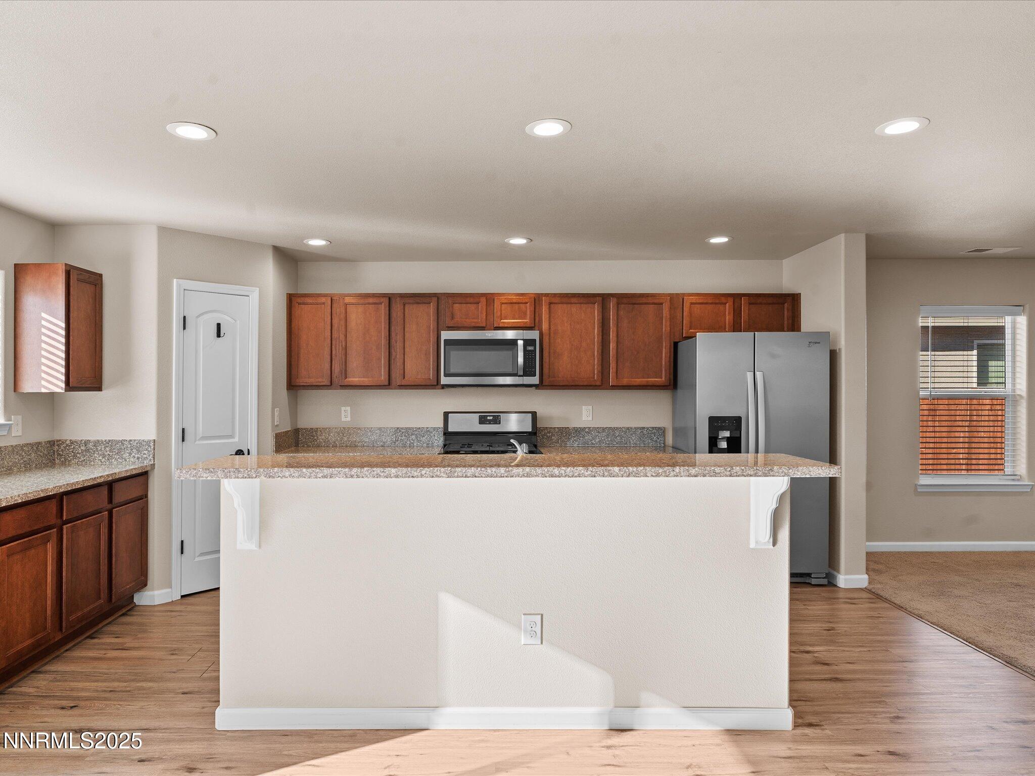 2541 Milano Way Fallon, NV 89406 - Photo 12 of 47 a kitchen with stainless steel appliances granite countertop a refrigerator a sink dishwasher a stove and white countertops with wooden floor
