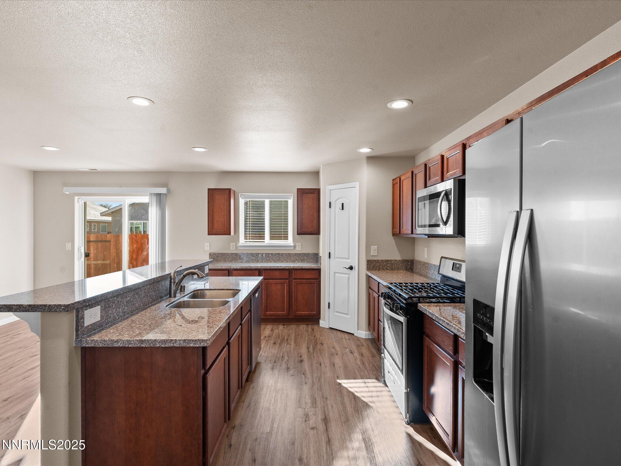 2541 Milano Way Fallon, NV 89406 - Photo 14 of 47 a kitchen with stainless steel appliances granite countertop a sink stove and refrigerator