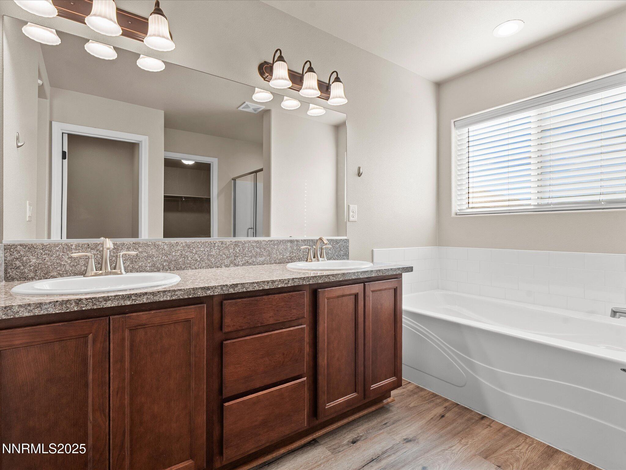 2541 Milano Way Fallon, NV 89406 - Photo 24 of 47 a bathroom with a granite countertop sink a large mirror and a bathtub