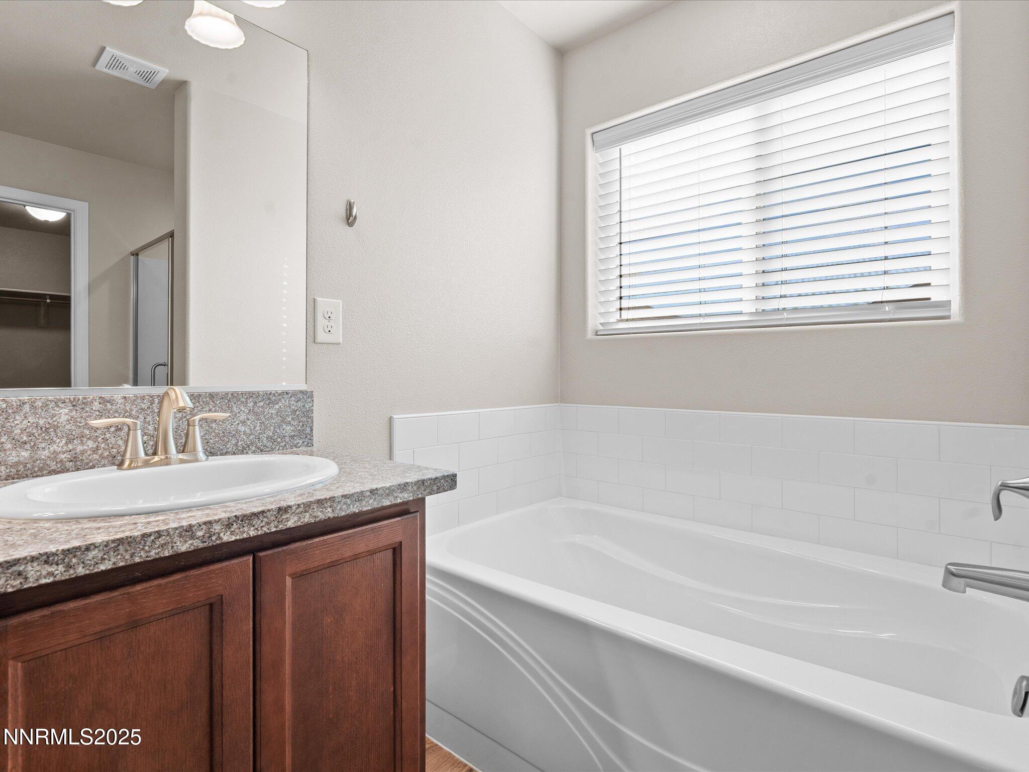 2541 Milano Way Fallon, NV 89406 - Photo 25 of 47 a bathroom with a granite countertop sink and a bathtub