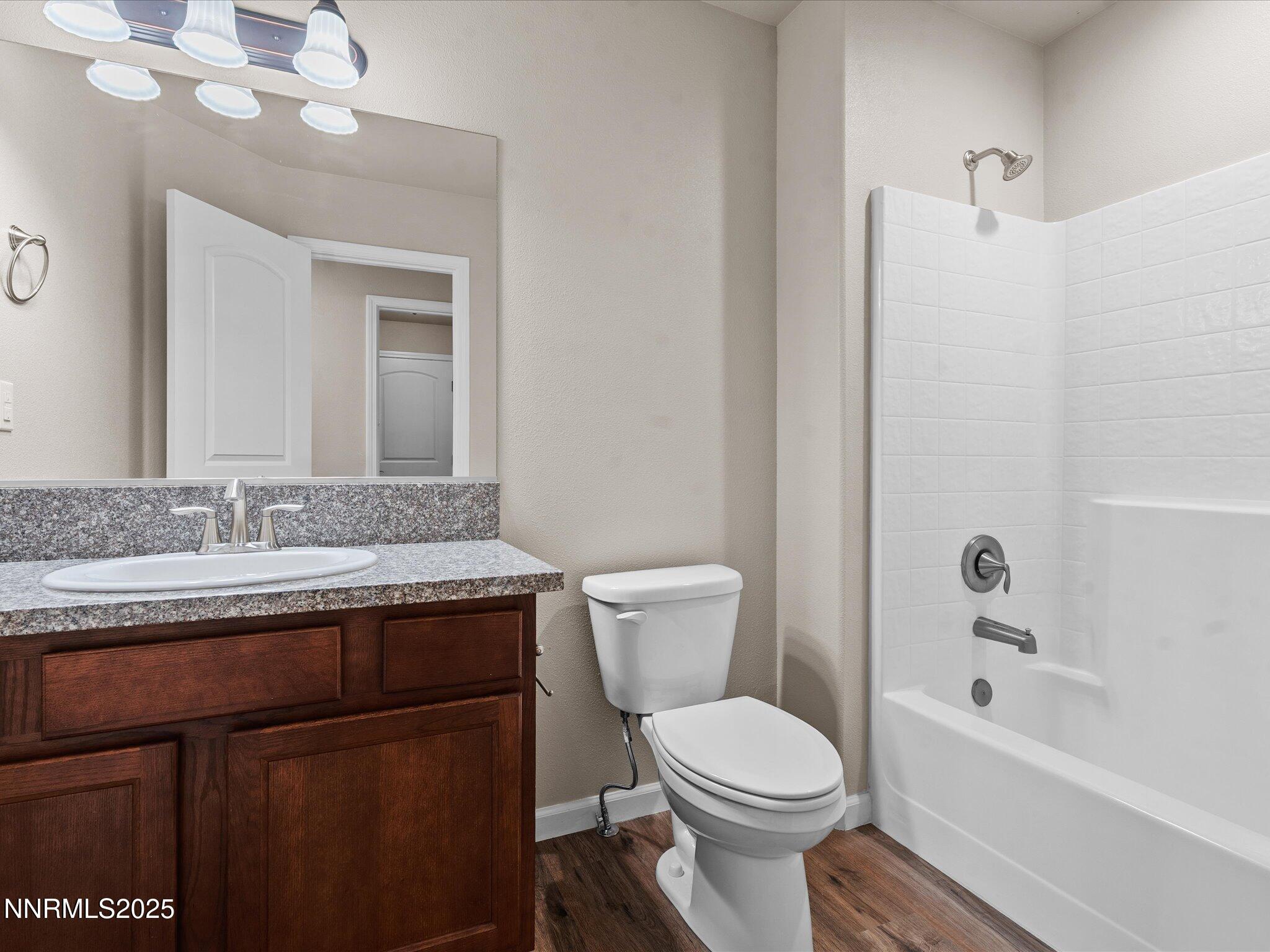 2541 Milano Way Fallon, NV 89406 - Photo 29 of 47 a bathroom with a granite countertop sink toilet a mirror and shower