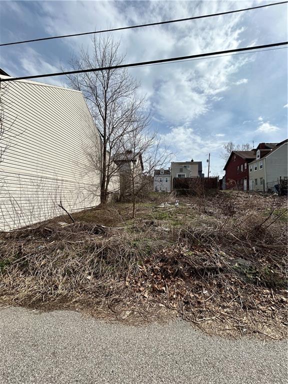 a view of a dry yard with wooden fence