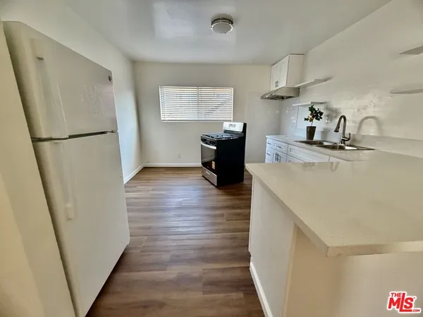 a kitchen with a refrigerator a stove a sink and a window