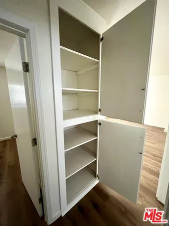 a view of walk in closet with empty racks