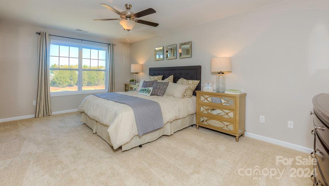 271 Creekview Road Hendersonville, NC 28792 - Photo 23 of 36 a bedroom with a bed a window and a chandelier