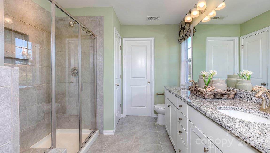 271 Creekview Road Hendersonville, NC 28792 - Photo 28 of 36 a bathroom with a granite countertop sink a mirror and a shower