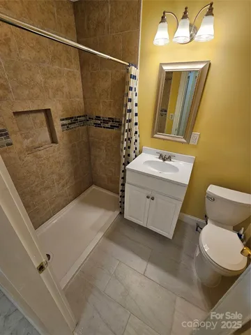 a bathroom with a granite countertop sink mirror vanity and toilet