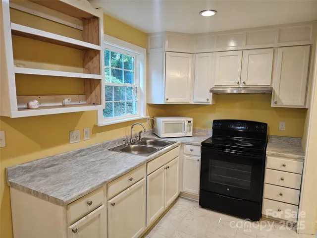 a kitchen with a stove window and cabinets