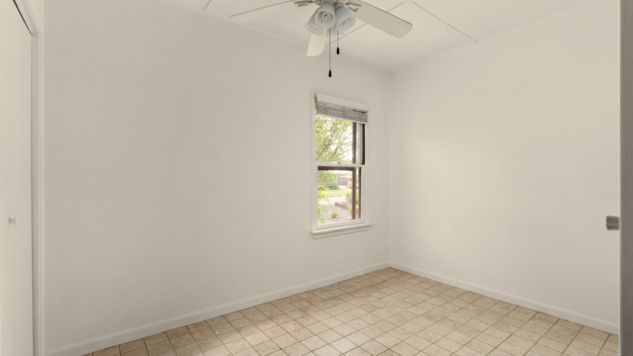 206 East Skyview Road Austin, TX 78752 - Photo 23 of 32 3rd bedroom. A well-lit bedroom features practical tile flooring and a ceiling fan for comfort.
