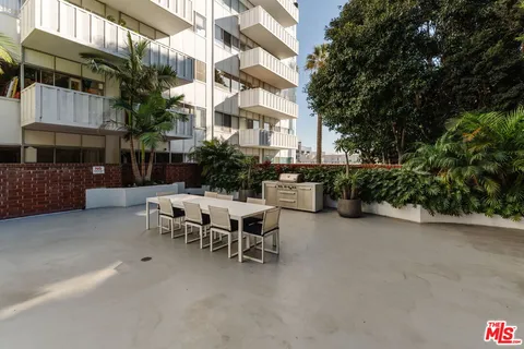 a view of a patio with a table and chairs and potted plants