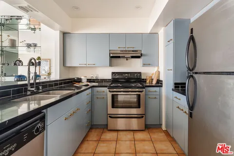 a kitchen with stainless steel appliances a refrigerator sink and white cabinets