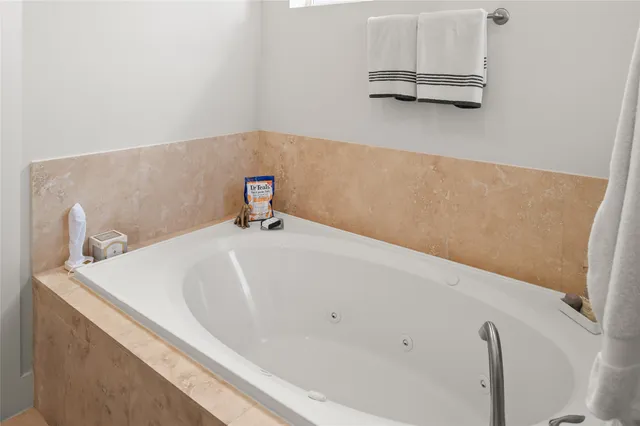 a bathroom with a granite countertop tub sink and mirror