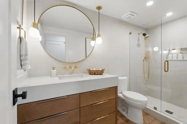 a bathroom with a sink a toilet and a mirror