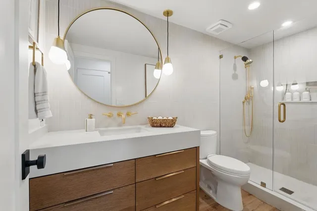 a bathroom with a sink a toilet and a mirror