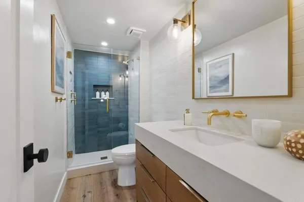 a bathroom with a sink a toilet and shower